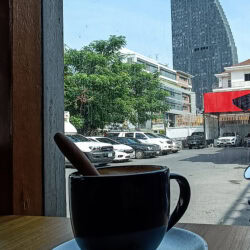 Il caffè del mattino, con grattacielo Ideo Q oltre la vetrina.