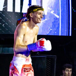 Erik Husiev, fascia in testa e pantaloncini rossi, sul ring.