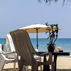 Sdraio e ombrellone sulla spiaggia di BaanYai, a Koh Mak, davanti al mare calmo del golfo di Thailandia.